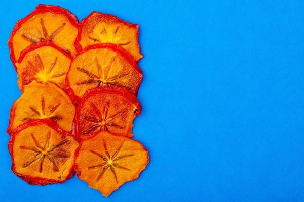 top-view-of-dried-persimmon-slices-on-a-blue-background-free-photo