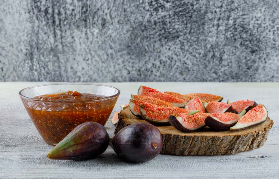 fig-jam-with-figs-bowl-grungy-wooden-board-side-view