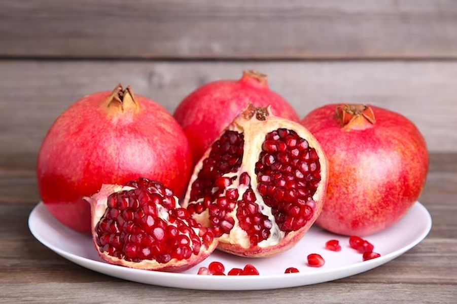 pomegranates-on-white-plate-on-a-brown-background_106006-301