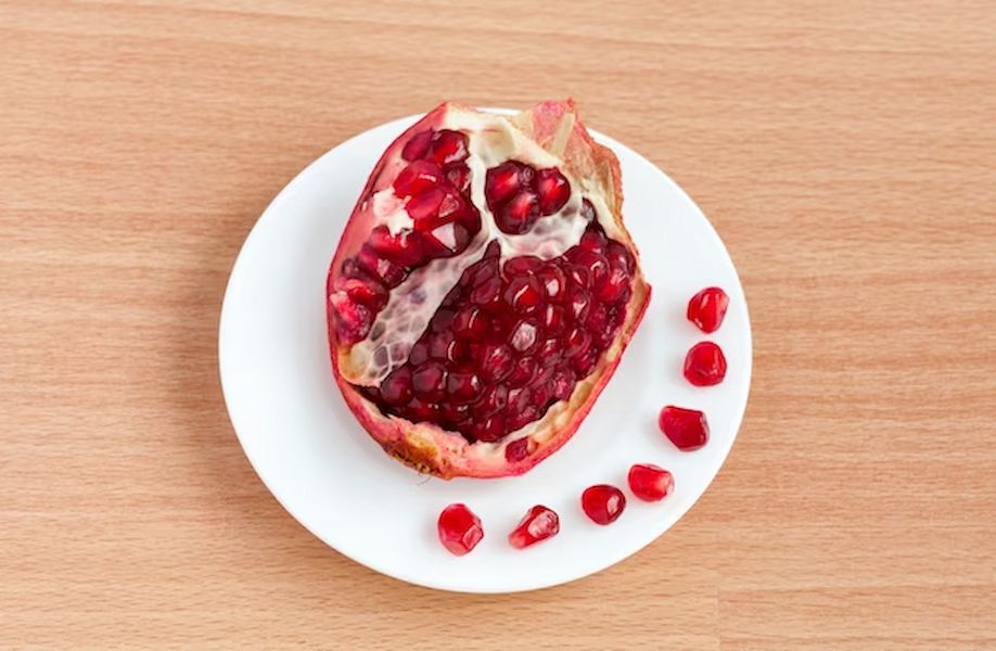 cut-pomegranate-grains-plate_127746-1053