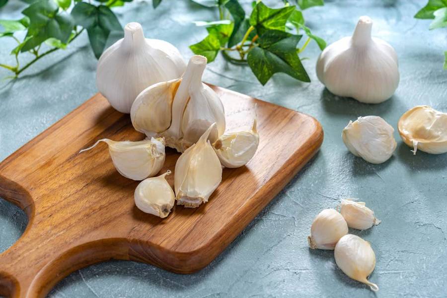 freshly-bought-garlic-bulbs-on-top-of-a-wood-chopping-board.